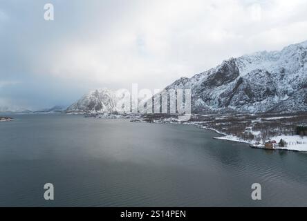 Schneebedeckte Berge entlang eines Fjords bei Holdoya Island, Lofoten, Norwegen Stockfoto
