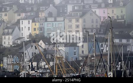 Harbour, Brixham, Devon, Großbritannien. Dezember 2024. Ein GV (General View) gegenüber dem Hafen mit Häusern und Geschäften auf dem Hügel dahinter. Stockfoto