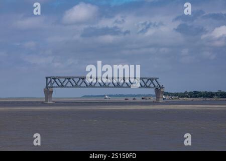 26. Juli 2019: Munshiganj, Bangladesch: Bauarbeiten an der Padma Mehrzweckbrücke überspannt den Padma River unter einem bewölkten Himmel. Stockfoto