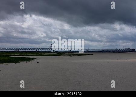 26. Juli 2019: Munshiganj, Bangladesch: Bauarbeiten an der Padma Mehrzweckbrücke überspannt den Padma River unter einem bewölkten Himmel. Stockfoto