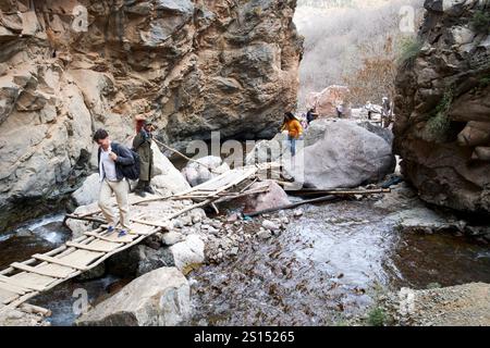 Touristen gehen über eine wackelige Holzbrücke auf dem Weg zu den imlil-Wasserfällen imlil-Tal imlil-marokko Stockfoto