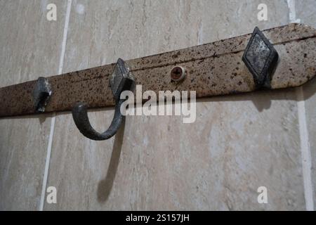 Alte und kaputte, rostige Kleiderbügel oder Gestell an der Wand Stockfoto