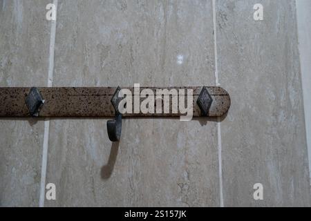 Alte und kaputte, rostige Kleiderbügel oder Gestell an der Wand Stockfoto