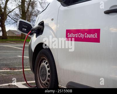 Swinton, Manchester, Großbritannien, 31-12-2024: Aufladen eines elektrischen Van an einer öffentlichen Station auf einem Parkplatz. Salford council. Stockfoto