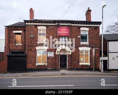 Swinton, Manchester, Großbritannien, 31-12-2024: Leerer Pub Swinton 'The Football' mit Bordscheiben in einer ruhigen Straße. Stockfoto