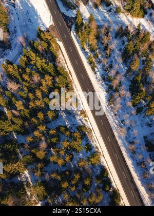 Blick aus der Vogelperspektive auf eine schneebedeckte Straße in gerader Linie, Seewald, Schwarzwald, Deutschland, Europa Stockfoto