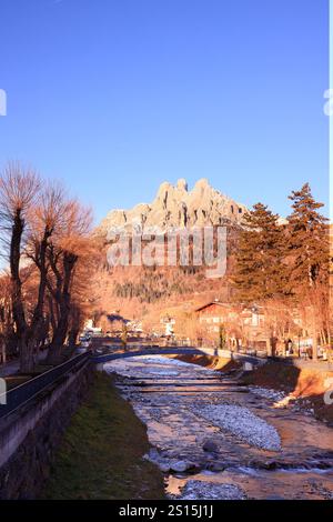 Primiero paese e vista sulle Pale di San Martino durante il tramonto con luci calde e cielo blu Stockfoto