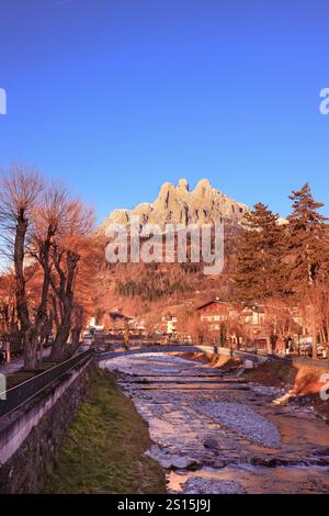 Primiero paese e vista sulle Pale di San Martino durante il tramonto con luci calde e cielo blu Stockfoto