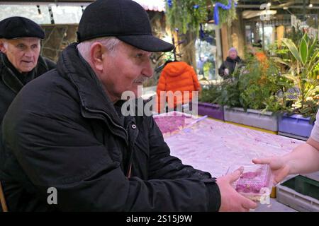 USCHHOROD, URAINE - 30. DEZEMBER 2024 - Ein Freiwilliger verteilt gekleideten Heringssalat an ältere Menschen in Uschhorod, Westukraine Stockfoto