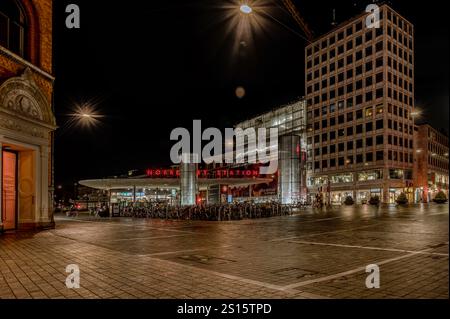 Norreport Station in Kopenhagen bei Nacht mit reflektierenden Neonschildern auf dem Bürgersteig, Dänemark, 12. Dezember 2024 Stockfoto