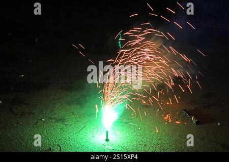 Feuerwerk in der Silvesternacht ein Bodenfeuerwerk sprüht seinen farbigen und grellen Inhalt in die Luft und wurde von einer jungen Familie mit fröhlichen Kindern in einem Vorort gezündet. Essen Nordrhein-Westfalen Deutschland *** Feuerwerk zu Silvester Ein Bodenfeuerwerk sprüht seinen bunten und hellen Inhalt in die Luft und wurde von einer jungen Familie mit glücklichen Kindern in einem Vorort Essen Nordrhein-Westfalen Deutschland gestartet Stockfoto