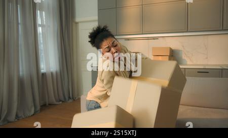Weibliche Hauseigentümerin Afroamerikanerin Mieterin zieht in neues Haus Umzug Carry Pappe Lieferung Pakete müde Kurier Drop Boxen Crash Ausfall Stockfoto