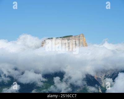 LUFTAUFNAHME. Großer isolierter Monolith, der über einem Wolkenmeer auftaucht. Mont Aiguille (2087 m). Chichilianne, Isère, Auvergne-Rhône-Alpes, Frankreich. Stockfoto