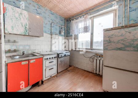 Küche in schlechtem Zustand in einem verlassenen Gebäude. Verlassenes Haus im Inneren. Dreckiges Zimmer. Altes Sowjetisches Armes Inneres. Weitwinkel Stockfoto