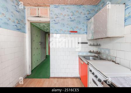 Küche in schlechtem Zustand in einem verlassenen Gebäude. Verlassenes Haus im Inneren. Dreckiges Zimmer. Altes Sowjetisches Armes Inneres. Weitwinkel Stockfoto