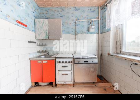 Küche in schlechtem Zustand in einem verlassenen Gebäude. Verlassenes Haus im Inneren. Dreckiges Zimmer. Altes Sowjetisches Armes Inneres. Weitwinkel Stockfoto