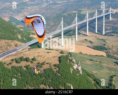 LUFT-LUFT-ANSICHT. Ein Paramotor, der in der Nähe des Viadukts von Millau fliegt, der höchsten Brücke der Welt seit 2020. Millau, Tarn Valley, Aveyron, Frankreich. Stockfoto