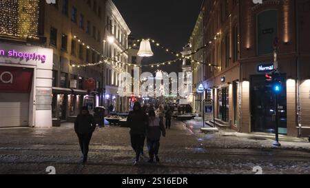 Oslo, Norwegen. Dezember 2024 31. Die Menschen laufen auf einer mit festlichen Lichtern geschmückten Straße in Oslo, Norwegen, 31. Dezember 2024. Quelle: Zhang Yuliang/Xinhua/Alamy Live News Stockfoto