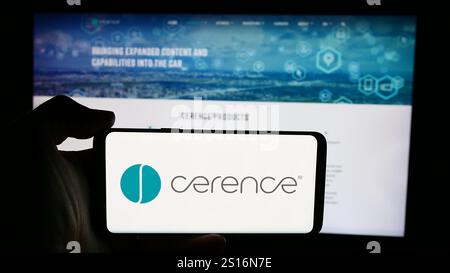 In dieser Abbildung hält eine Person ein Smartphone mit dem Logo des US-amerikanischen Automobilsoftwareunternehmens Cerence Inc. Vor der Unternehmenswebsite. Stockfoto