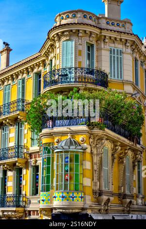 Cannes, Frankreich - 7. September 2024 : in der Straße befindet sich ein schönes gelbes Art déco-Gebäude. Da ist ein farbiges Buntglas. Stockfoto