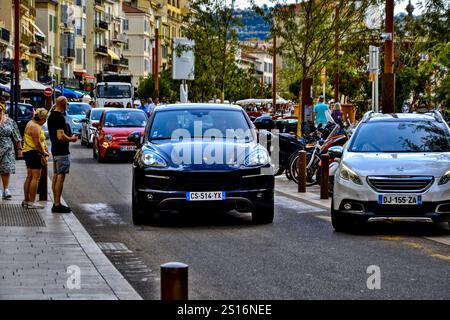 Cannes, Frankreich - 7. September 2024 : Porsche Cayenne fährt auf einer Straße mit Fußgängern. Stockfoto