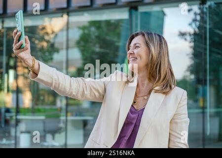 Selbstbewusste Geschäftsfrau, die draußen ein Selfie macht Stockfoto