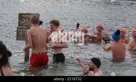Jena, Deutschland. Januar 2025. Mehrere hundert Badefreunde schwimmen am Neujahrstag im Schleichersee bei einer Lufttemperatur von 6 Grad und einer Wassertemperatur von rund 4 Grad. Zum fünften Mal lud die Jenaer Bäder- und Freizeitgesellschaft 2025 zum gemeinsamen Schwimmen im Südbad ein. Quelle: Bodo Schackow/dpa/Alamy Live News Stockfoto