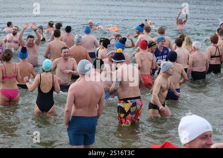 Jena, Deutschland. Januar 2025. Mehrere hundert Badefreunde schwammen am Neujahrstag im Schleichersee bei einer Lufttemperatur von 6 Grad und einer Wassertemperatur von rund 4 Grad. Zum fünften Mal lud die Jenaer Bäder- und Freizeitgesellschaft 2025 zum gemeinsamen Schwimmen im Südbad ein. Quelle: Bodo Schackow/dpa/Alamy Live News Stockfoto