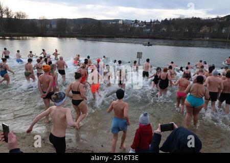 Jena, Deutschland. Januar 2025. Mehrere hundert Badefreunde schwimmen am Neujahrstag im Schleichersee bei einer Lufttemperatur von 6 Grad und einer Wassertemperatur von rund 4 Grad. Zum fünften Mal lud die Jenaer Bäder- und Freizeitgesellschaft 2025 zum gemeinsamen Schwimmen im Südbad ein. Quelle: Bodo Schackow/dpa/Alamy Live News Stockfoto