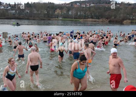 Jena, Deutschland. Januar 2025. Mehrere hundert Badefreunde schwimmen am Neujahrstag im Schleichersee bei einer Lufttemperatur von 6 Grad und einer Wassertemperatur von rund 4 Grad. Zum fünften Mal lud die Jenaer Bäder- und Freizeitgesellschaft 2025 zum gemeinsamen Schwimmen im Südbad ein. Quelle: Bodo Schackow/dpa/Alamy Live News Stockfoto
