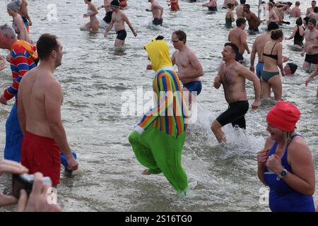 Jena, Deutschland. Januar 2025. Mehrere hundert Badefreunde schwimmen am Neujahrstag im Schleichersee bei einer Lufttemperatur von 6 Grad und einer Wassertemperatur von rund 4 Grad. Zum fünften Mal lud die Jenaer Bäder- und Freizeitgesellschaft 2025 zum gemeinsamen Schwimmen im Südbad ein. Quelle: Bodo Schackow/dpa/Alamy Live News Stockfoto