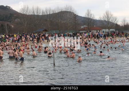 Jena, Deutschland. Januar 2025. Mehrere hundert Badefreunde schwimmen am Neujahrstag im Schleichersee bei einer Lufttemperatur von 6 Grad und einer Wassertemperatur von rund 4 Grad. Zum fünften Mal lud die Jenaer Bäder- und Freizeitgesellschaft 2025 zum gemeinsamen Schwimmen im Südbad ein. Quelle: Bodo Schackow/dpa/Alamy Live News Stockfoto