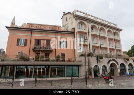 DESENZANO DEL GARDA, ITALIEN - 25. OKTOBER 2024: Szene in der Straße von Desenzano del Garda, mit Schwerpunkt auf dem Hotel Vittorio Stockfoto