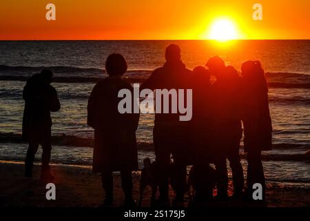 Isle Of Palms, Usa. Januar 2025. Die Menschen, die nur im Morgenlicht stehen, versammeln sich am Front Beach, um den ersten Sonnenaufgang des Jahres über dem Atlantischen Ozean am 1. Januar 2025 in Isle of Palms, South Carolina, zu beobachten. Quelle: Richard Ellis/Richard Ellis/Alamy Live News Stockfoto