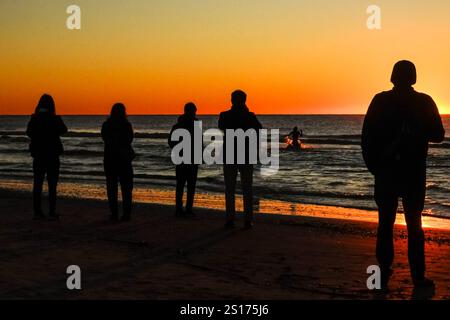 Isle Of Palms, Usa. Januar 2025. Die Menschen, die nur im Morgenlicht stehen, versammeln sich am Front Beach, um den ersten Sonnenaufgang des Jahres über dem Atlantischen Ozean am 1. Januar 2025 in Isle of Palms, South Carolina, zu beobachten. Quelle: Richard Ellis/Richard Ellis/Alamy Live News Stockfoto