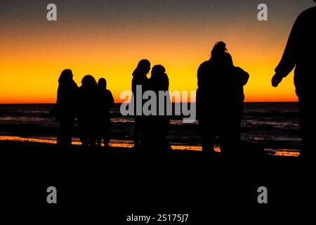 Isle Of Palms, Usa. Januar 2025. Die Menschen, die nur im Morgenlicht stehen, versammeln sich am Front Beach, um den ersten Sonnenaufgang des Jahres über dem Atlantischen Ozean am 1. Januar 2025 in Isle of Palms, South Carolina, zu beobachten. Quelle: Richard Ellis/Richard Ellis/Alamy Live News Stockfoto