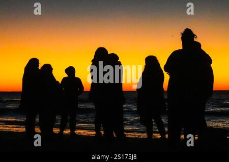 Isle Of Palms, Usa. Januar 2025. Die Menschen, die nur im Morgenlicht stehen, versammeln sich am Front Beach, um den ersten Sonnenaufgang des Jahres über dem Atlantischen Ozean am 1. Januar 2025 in Isle of Palms, South Carolina, zu beobachten. Quelle: Richard Ellis/Richard Ellis/Alamy Live News Stockfoto