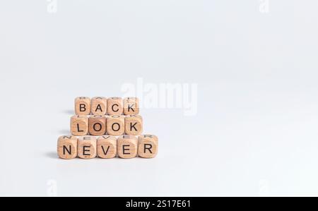 Schauen Sie nie zurück! Phrase auf Holzblöcken mit schwarzen Buchstaben auf weißem Hintergrund Stockfoto