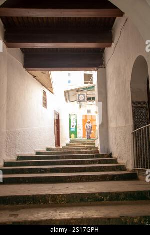 In Moulay Idriss, Marokko, am 06.08.2024, kletterte Frau die Treppe in der alten Medina Stockfoto