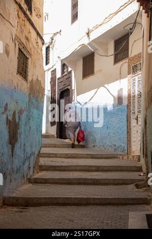 In Moulay Idriss, Marokko, am 06.08.2024, kletterte Frau die Treppe in der alten Medina Stockfoto