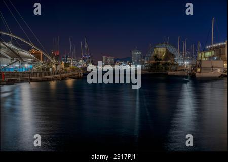 Eine ruhige nächtliche Hafenszene mit einem atemberaubenden Blick auf die Lichter der Stadt, die sich wunderschön auf dem ruhigen Wasser spiegeln Stockfoto