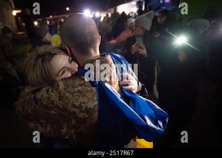 Nicht Offengelegt, Ukraine. 30. Dezember 2024. Ein ukrainischer Soldat umarmt seine Familie, nachdem er aus russischer Gefangenschaft in einem Gefangenenaustausch zwischen Russland und der Ukraine am 30. Dezember 2024 in der Ukraine entlassen wurde. Insgesamt 187 ukrainische Soldaten wurden von den Russen in einem Deal freigelassen, der von den Vereinigten Arabischen Emiraten verhandelt wurde. Quelle: Pool Photo/Ukrainische Präsidentenpresse/Alamy Live News Stockfoto