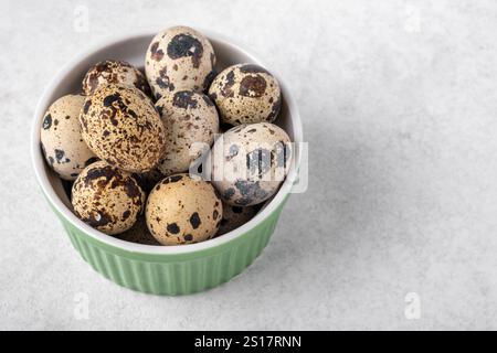 Eine Schüssel mit Wachteleiern auf einer strukturierten Oberfläche. Konzept der gesunden Ernährung Stockfoto