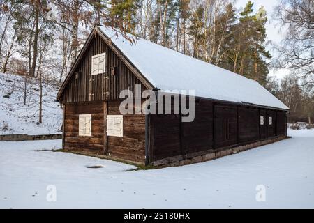 In Hembygdsparken, Hässleholm, steht ein altes Holzhaus friedlich im Schnee und bietet traditionellen Charme in einem Winterwunderland. Stockfoto