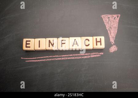 Einfach. Text in deutscher sprache auf schwarzem Tafel. Stockfoto