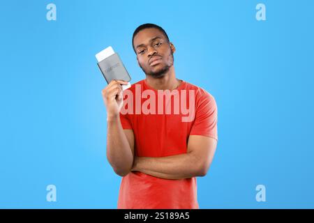 Unzufriedener Schwarzer Tourist Man Holding Travel Tickets Auf Blauem Hintergrund Stockfoto