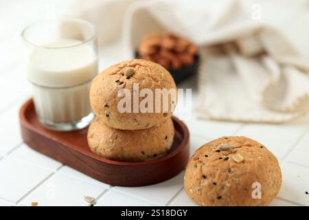 Kleines rundes Sauerteigbrot mit verschiedenen Samen, serviert mit Milch Stockfoto