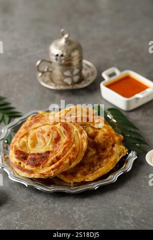 Roti Parata oder Roti Canai mit Lammcurry Sauce, Joghurt und Tee Stockfoto