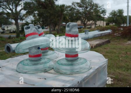 Elektrischer Isolator aus Glas aus Nahaufnahme auf einer Box in einer im Bau befindlichen elektrischen Umspannstation. Hochleistungsleitungen in Florida. Blauer Himmel. Upgrade Stockfoto