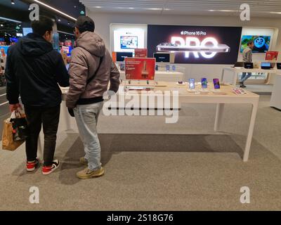 Leute, die sich Mobiltelefone ansehen und in einem Geschäft einkaufen. IPhone-Mobiltelefone auf dem Display Stockfoto